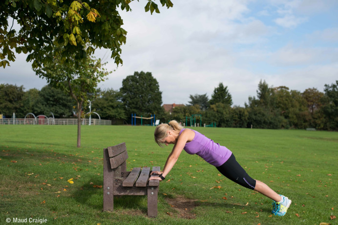Peta does pushups on a bench in the park. Copyright Maud Craigie.