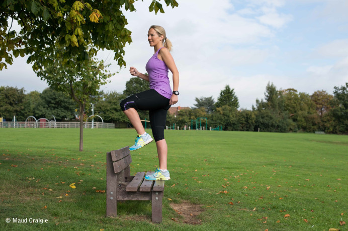 Peta does step ups on a bench in a park